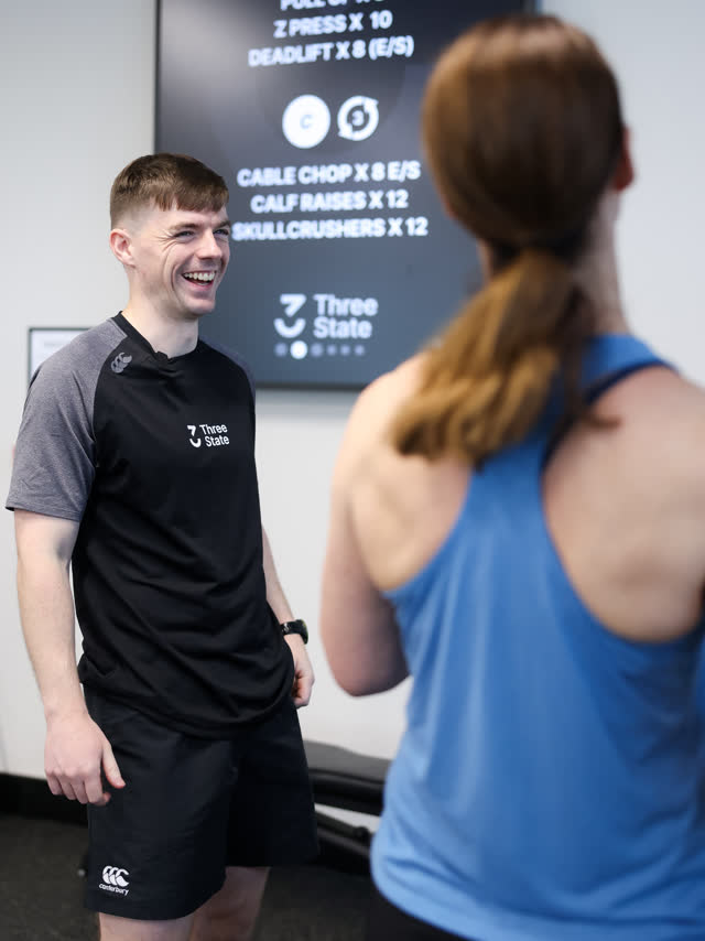 A coach smiling while working with a member