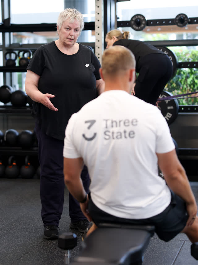A coach talking a member through an exercise