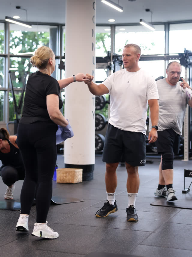 A coach and member fist-bumping
