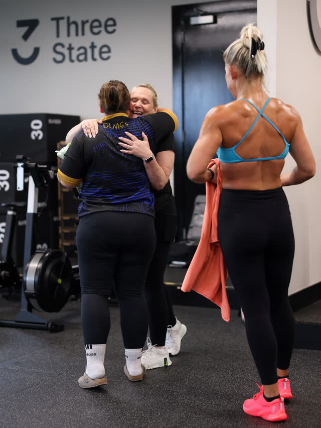 Two members sharing a hug after a session