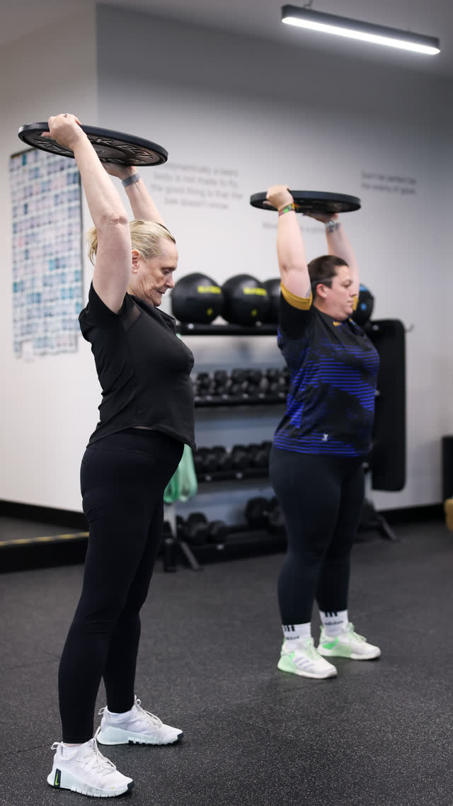 Two members pressing plates overhead together